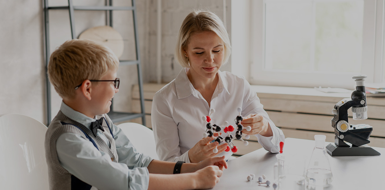 Female science tutor in Pembroke studying chemistry with student